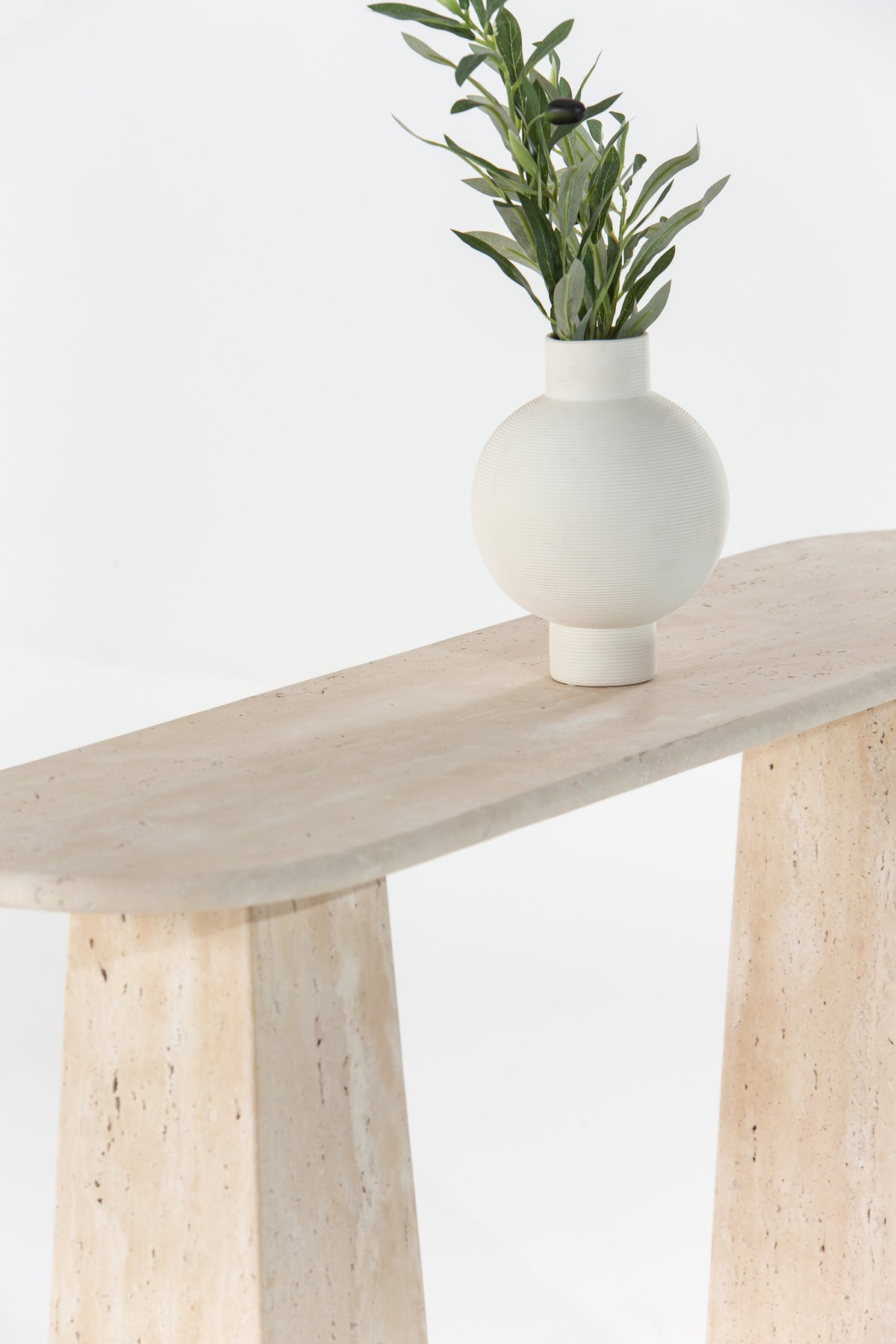 Détail du plateau et des pieds en travertin de la console Ilios