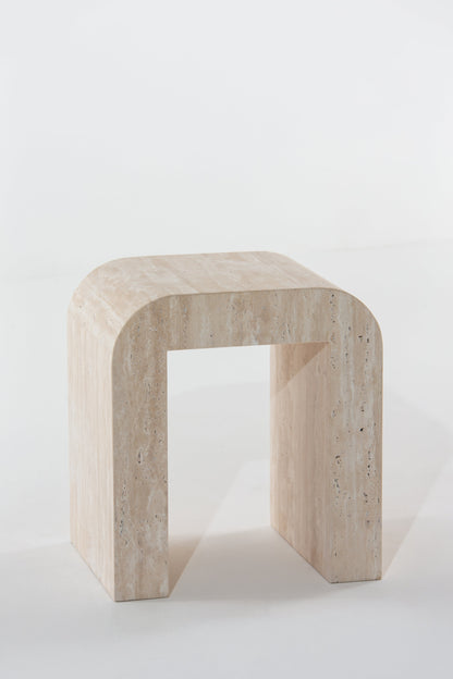 Table d'appoint en arche en travertin vue de trois quarts