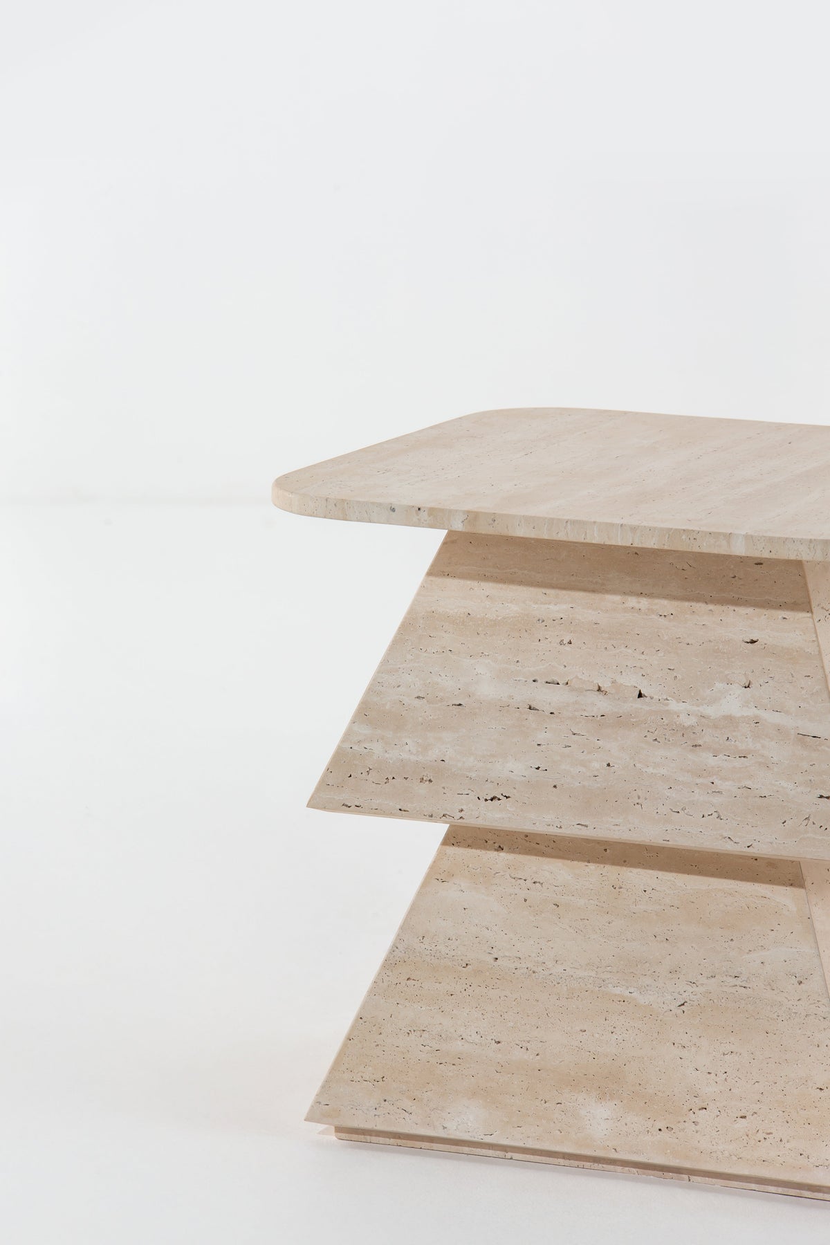 Superposition des volumes en travertin de la table Totem
